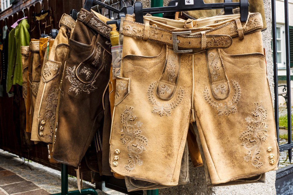 Embroidered Bavarian Lederhosen shorts hanging on an outdoor display rack. - Lederhosen For Sale