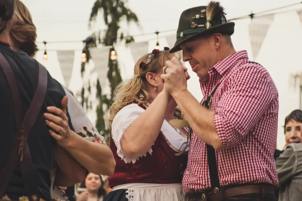 Your Definitive Guide to Oktoberfest - History, Traditions, and Must-Do Activities 1 Couple in traditional Bavarian attire dancing at Oktoberfest. - Lederhosen For Sale