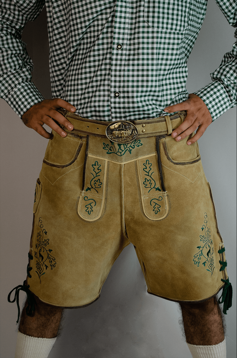 Handcrafted Oktoberfest Lederhosen in Light Gold 4 Front view of a man wearing light gold handcrafted Lederhosen shorts with detailed green oak leaf embroidery and a large ornate gold belt buckle. - Lederhosen For Sale