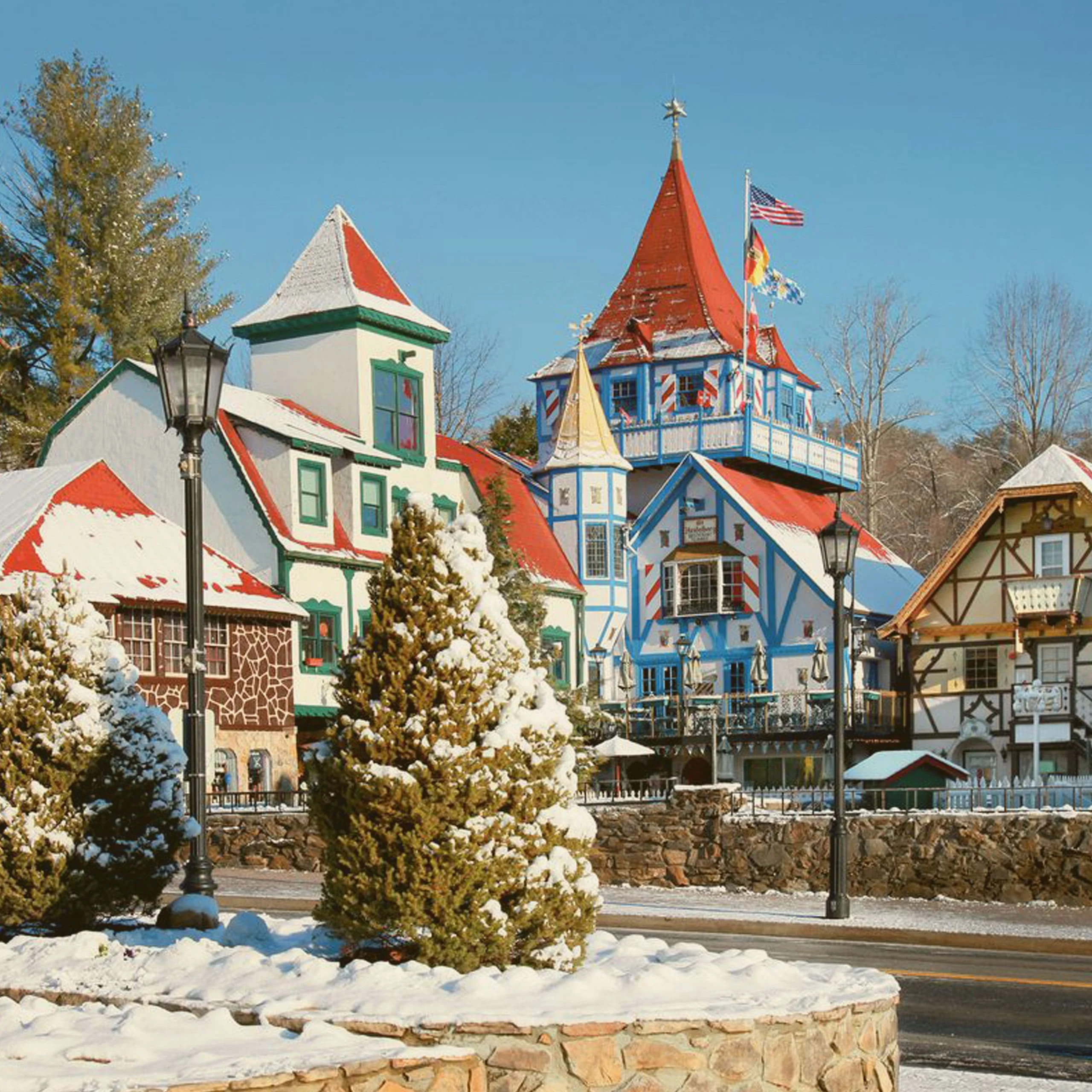 Bavarian-style architecture in Helen, Georgia, featuring colorful buildings and towers covered in snow during a winter day. - Lederhosen For Sale