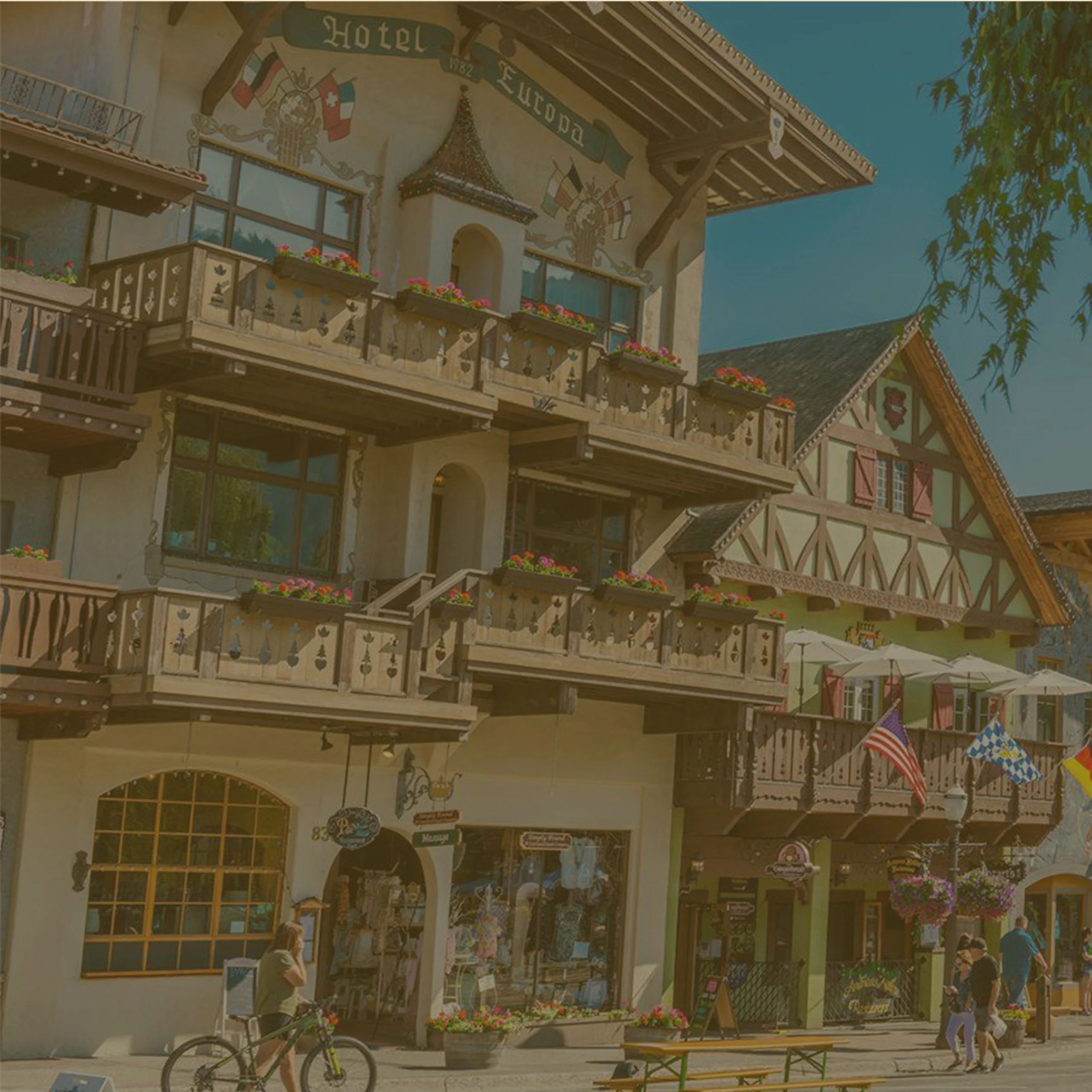 Traditional Bavarian-style architecture of Hotel Europa on a sunny street in Leavenworth, Washington. - Lederhosen For Sale
