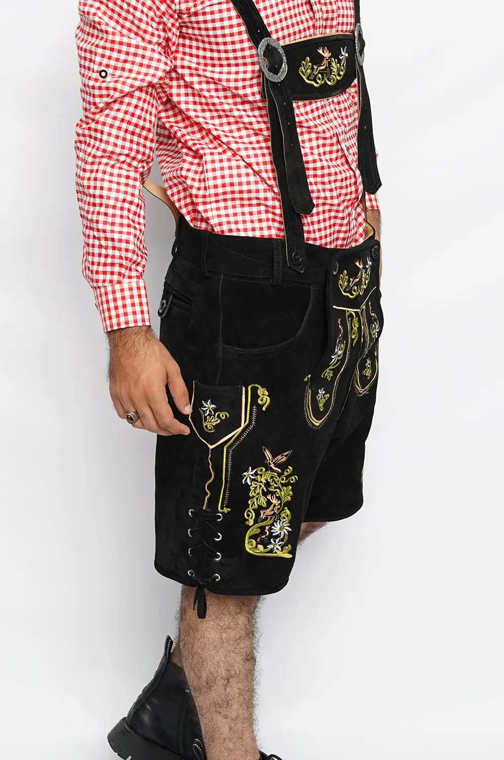 Side view of black suede Lederhosen shorts with colorful floral embroidery, leather laces, and suspenders. - Lederhosen For Sale