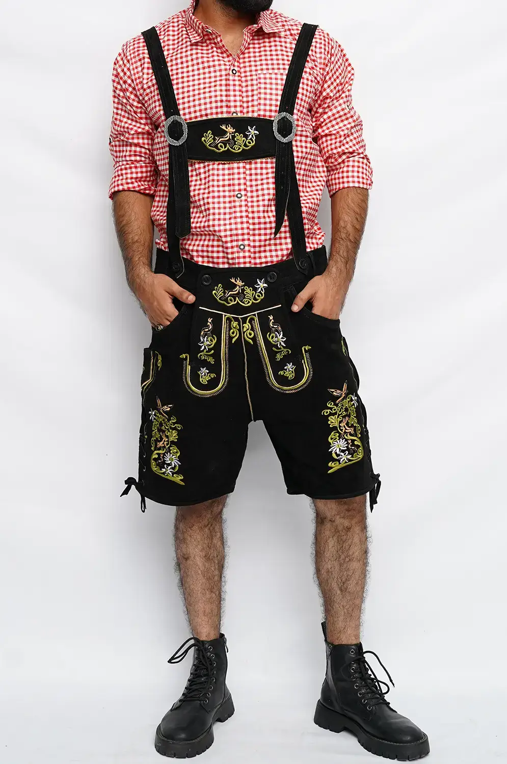 Man wearing traditional black embroidered Lederhosen with a red checkered shirt and black boots. - Lederhosen For Sale