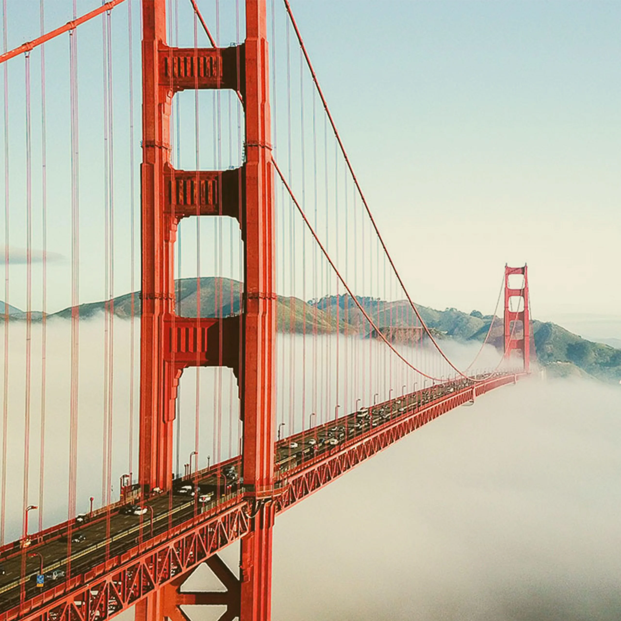 Aerial view of the Golden Gate Bridge in San Francisco surrounded by thick white fog under a clear sky. - Lederhosen For Sale